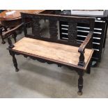 A carved oak settle with replacement seat,