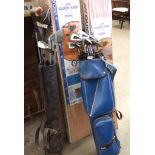 A blue golf bag containing nine Petron Peripheral Weighting gold clubs and a putter and another