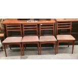 A set of four 1960s rail back teak dining chairs with brown upholstered seats [Please note - the