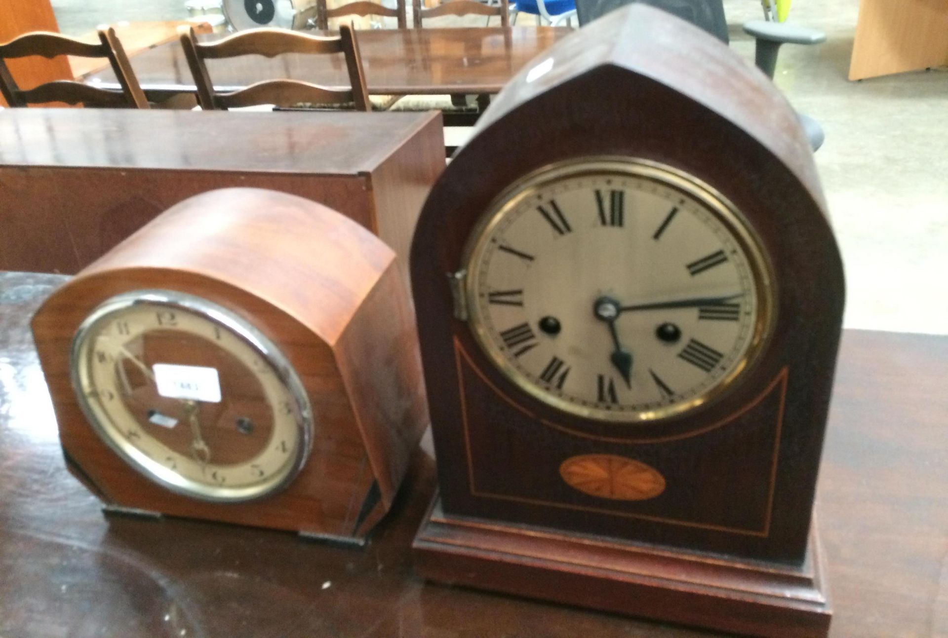 A mahogany arch top mantel clock with inlaid shell decoration (glass face missing) and a