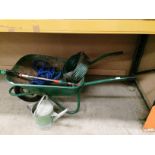 A green metal wheelbarrow, a riddle, two hoses,