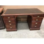 A Victorian mahogany finish eight drawer twin pedestal desk with brown vinyl upholstered top,