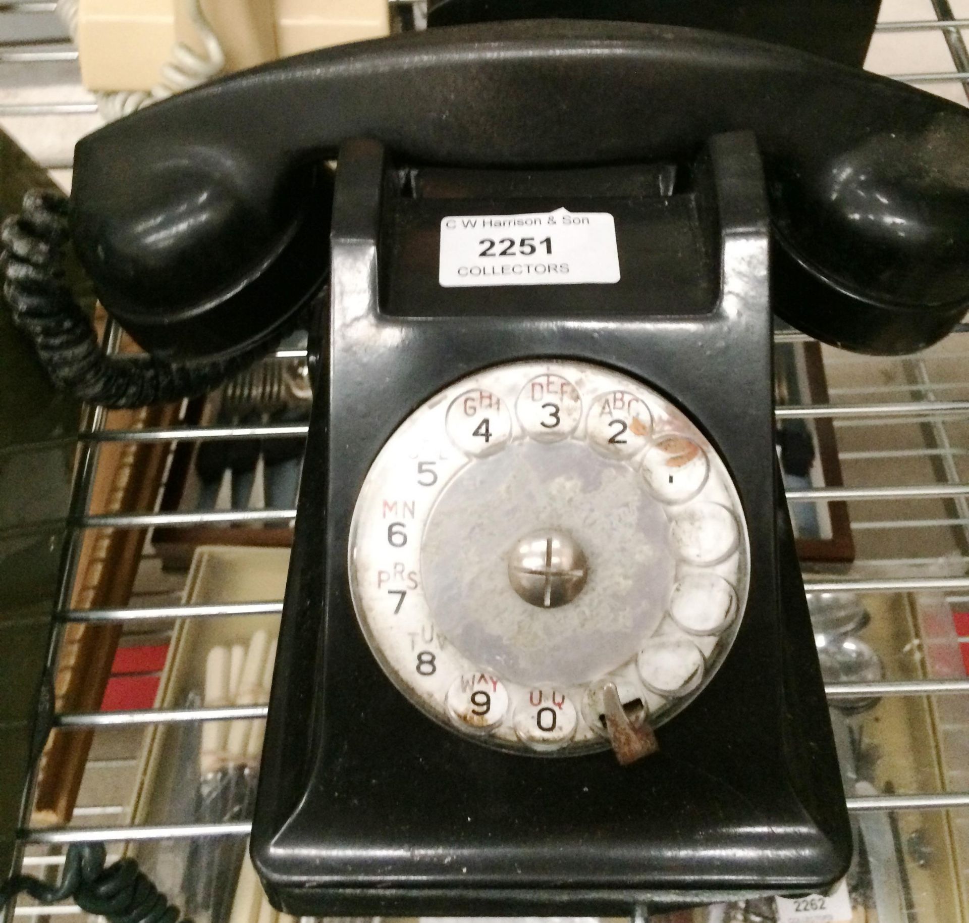 A black bakelite telephone - for use as a prop only - damage to front