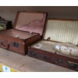 A brown leather and a brown fibre suitcase,