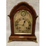 A mahogany cased arch top mantel clock with brass movement signed JJE England 30cm high (slight