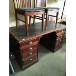 A Victorian mahogany finish eight drawer twin pedestal desk with brown vinyl upholstered top,