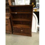 An oak bookcase with three open shelves over two door base 88 x 135cm