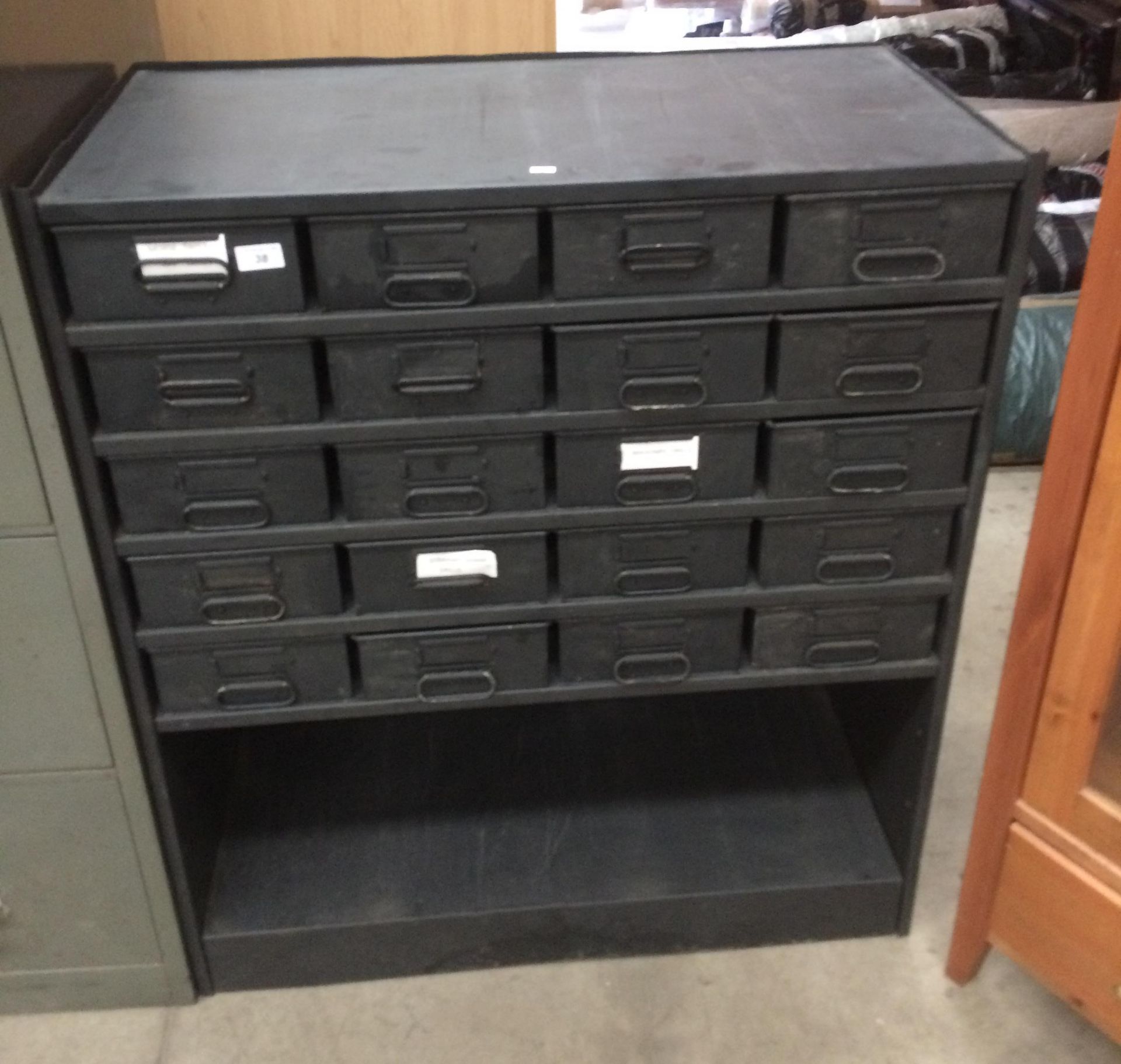 A black metal twenty drawer stores cabinet with under storage area - 85 x 40 x 100cm