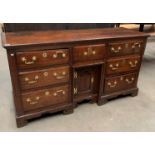 An 18th Century oak seven drawer single door sideboard,