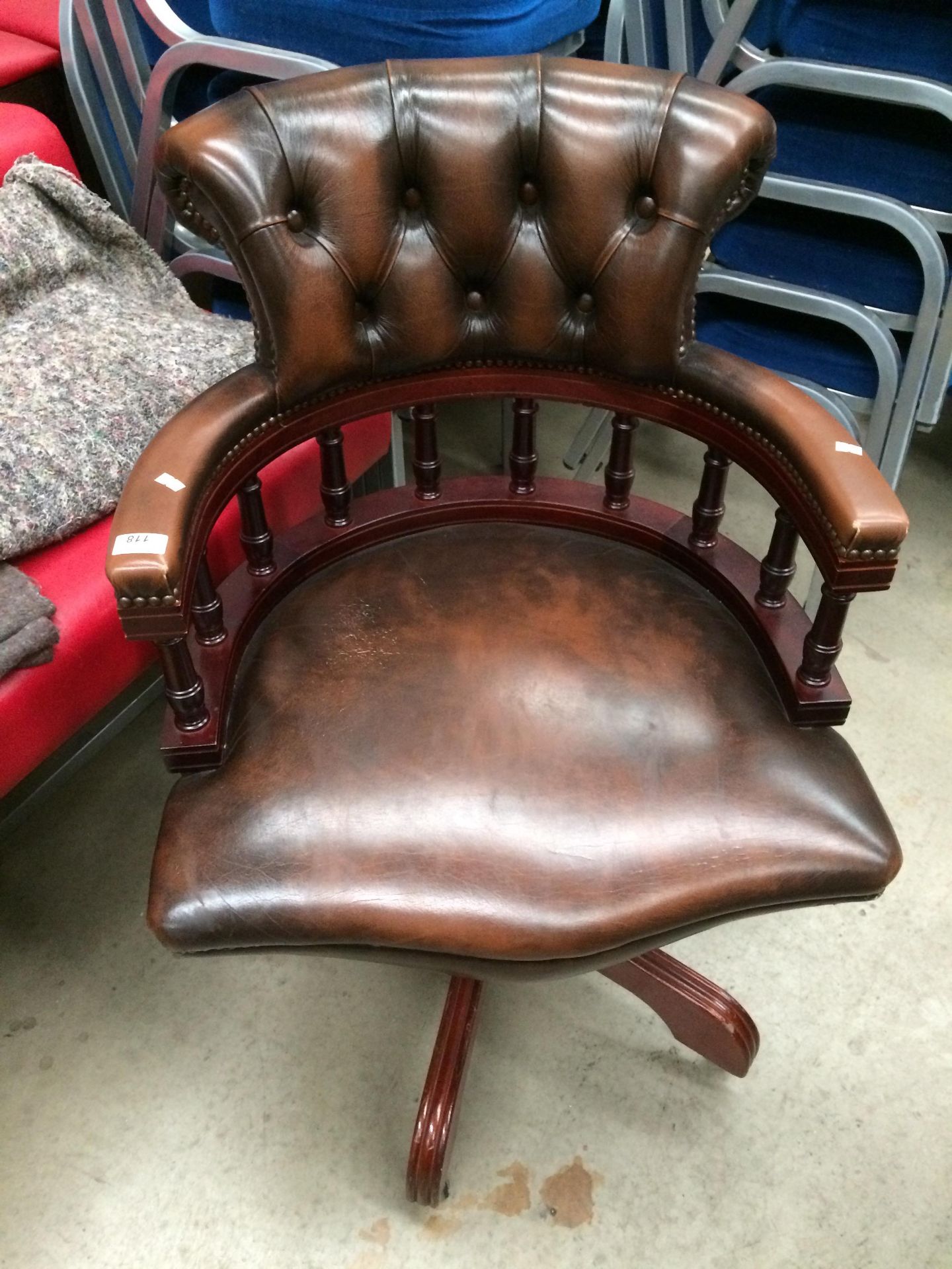 A reproduction brown leather finish swivel armchair