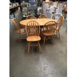 A pine finish 'D' ended extending dining table 106cm x 150cm extended and six hoop back matching