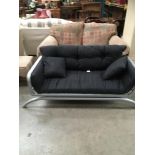 Grey metal framed futon style sofa with black upholstered cushions