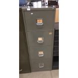 A grey metal four drawer filing cabinet complete with key