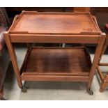 An oak tea trolley with two detachable trays