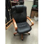 A pine framed black vinyl upholstered high back swivel armchair