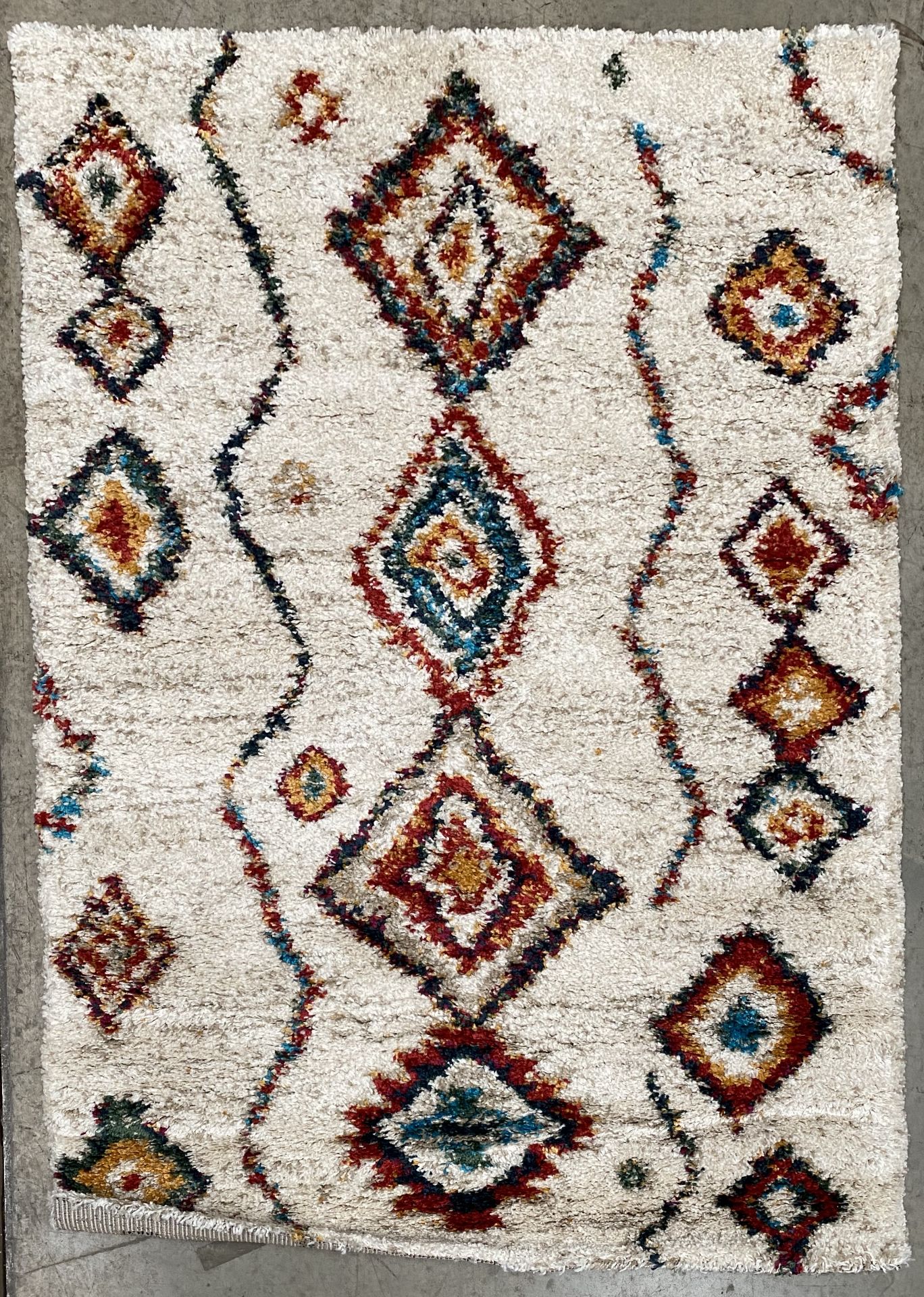 A diamond patterned multicoloured cream rug - 170cm x 120cm