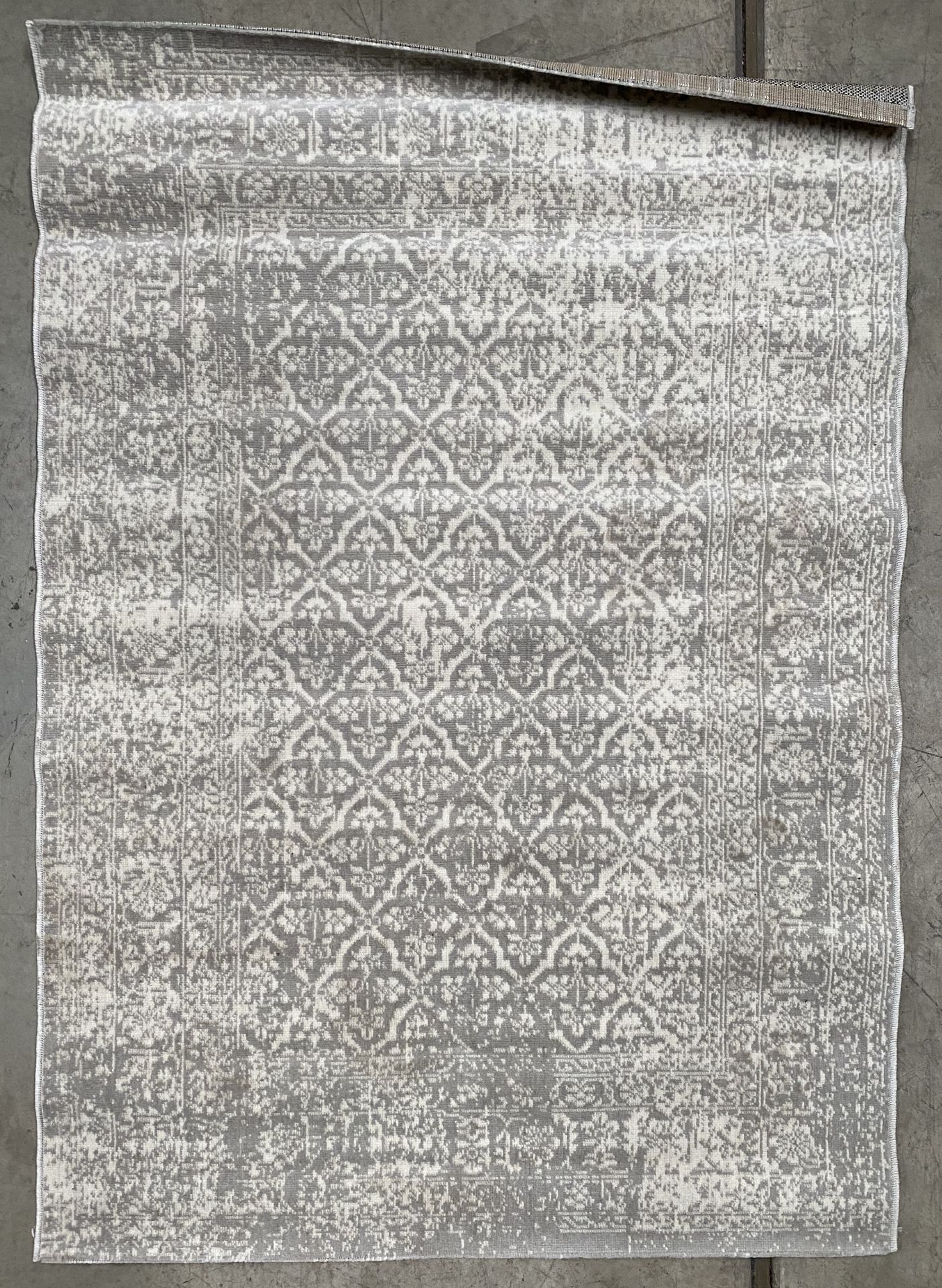 A grey and white floral patterned rug - 120cm x 170cm