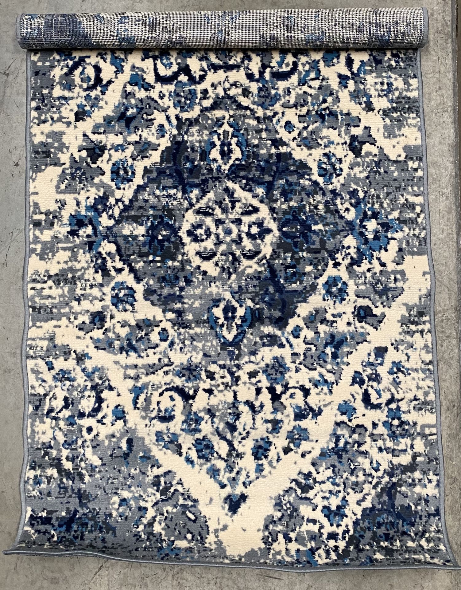 A blue and grey patterned rug - 90cm x 150cm