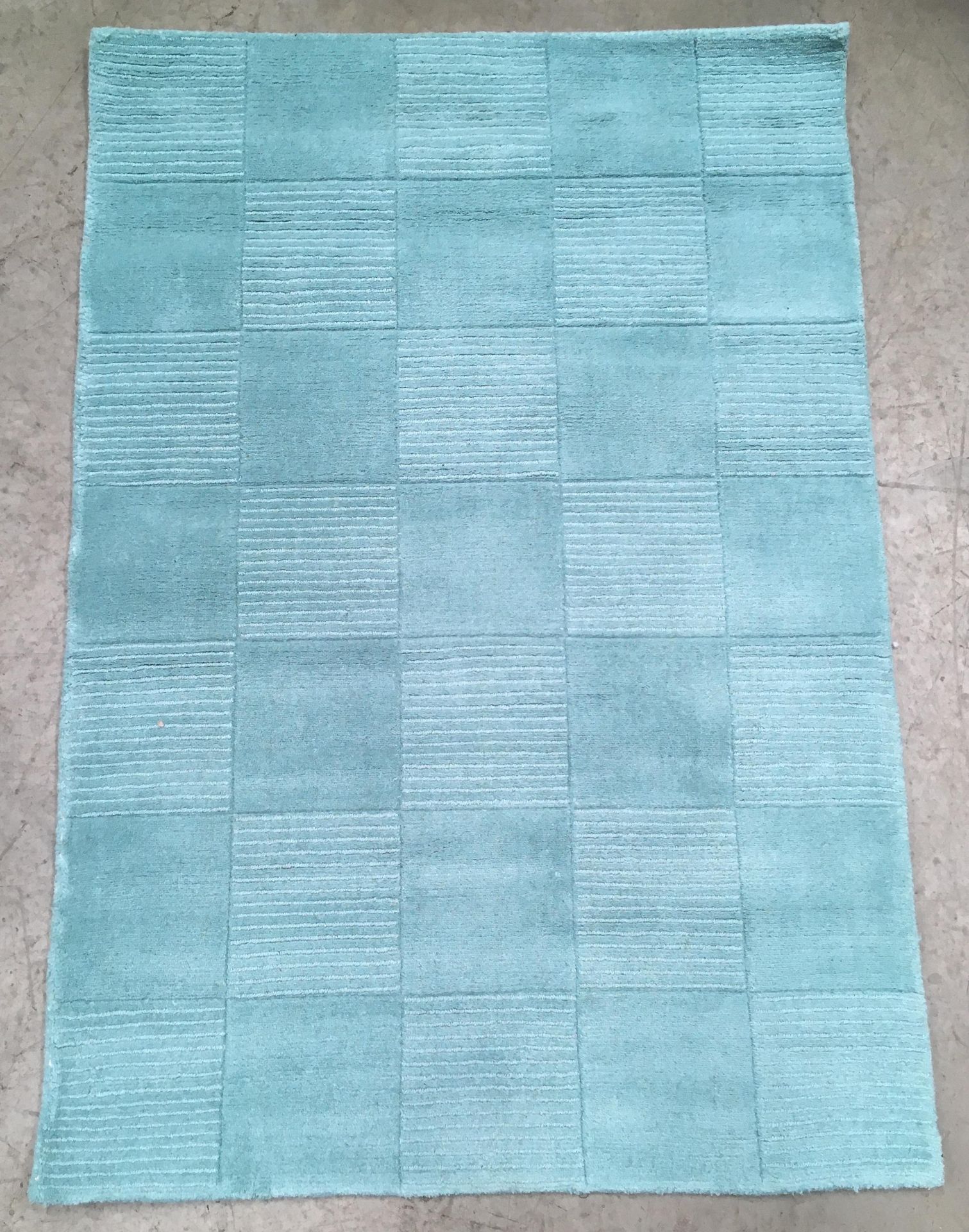 A Madison Wool teal rug - 110cm x 160cm