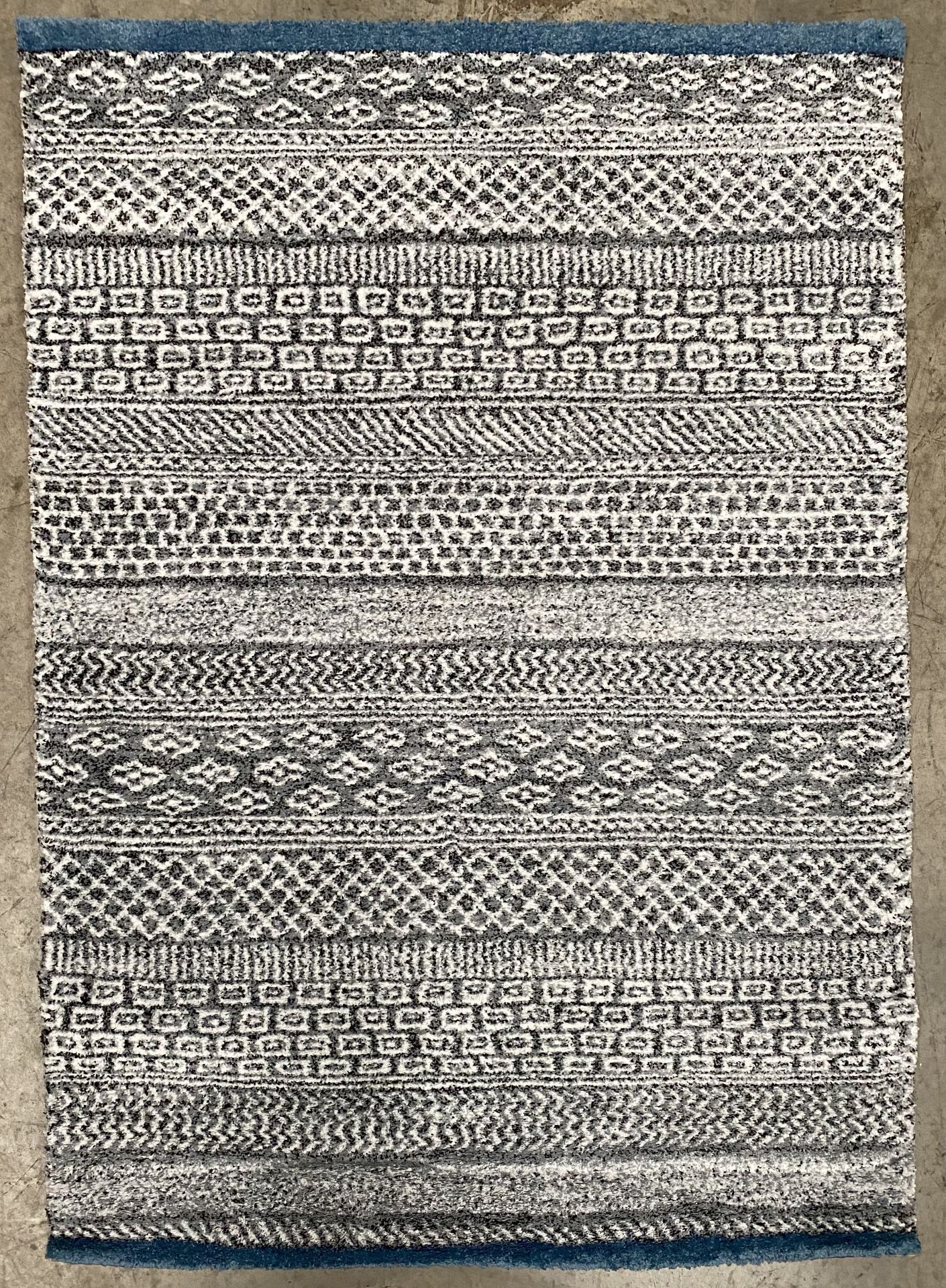 A patterned blue and grey rug - 170cm x 120cm