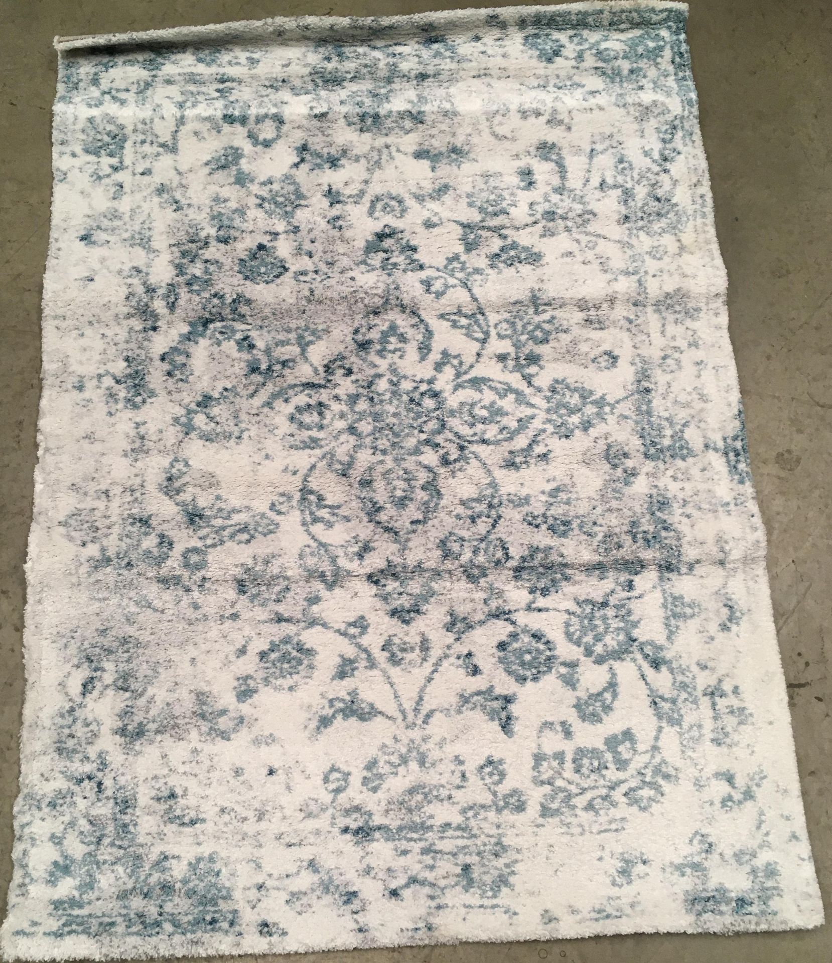 A white and light blue patterned rug - 170cm x 120cm