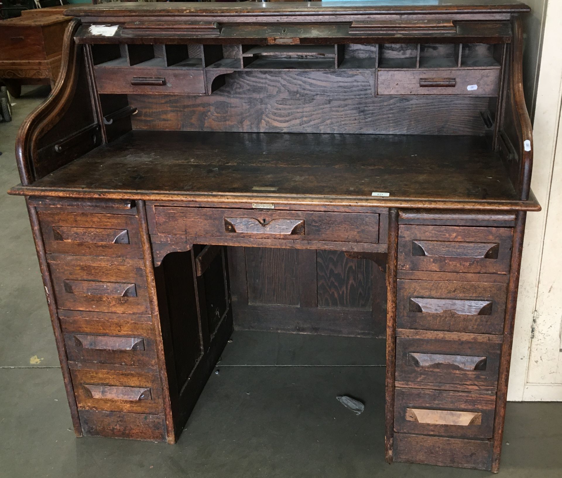 An oak nine drawer twin pedestal roll top desk 122cm long