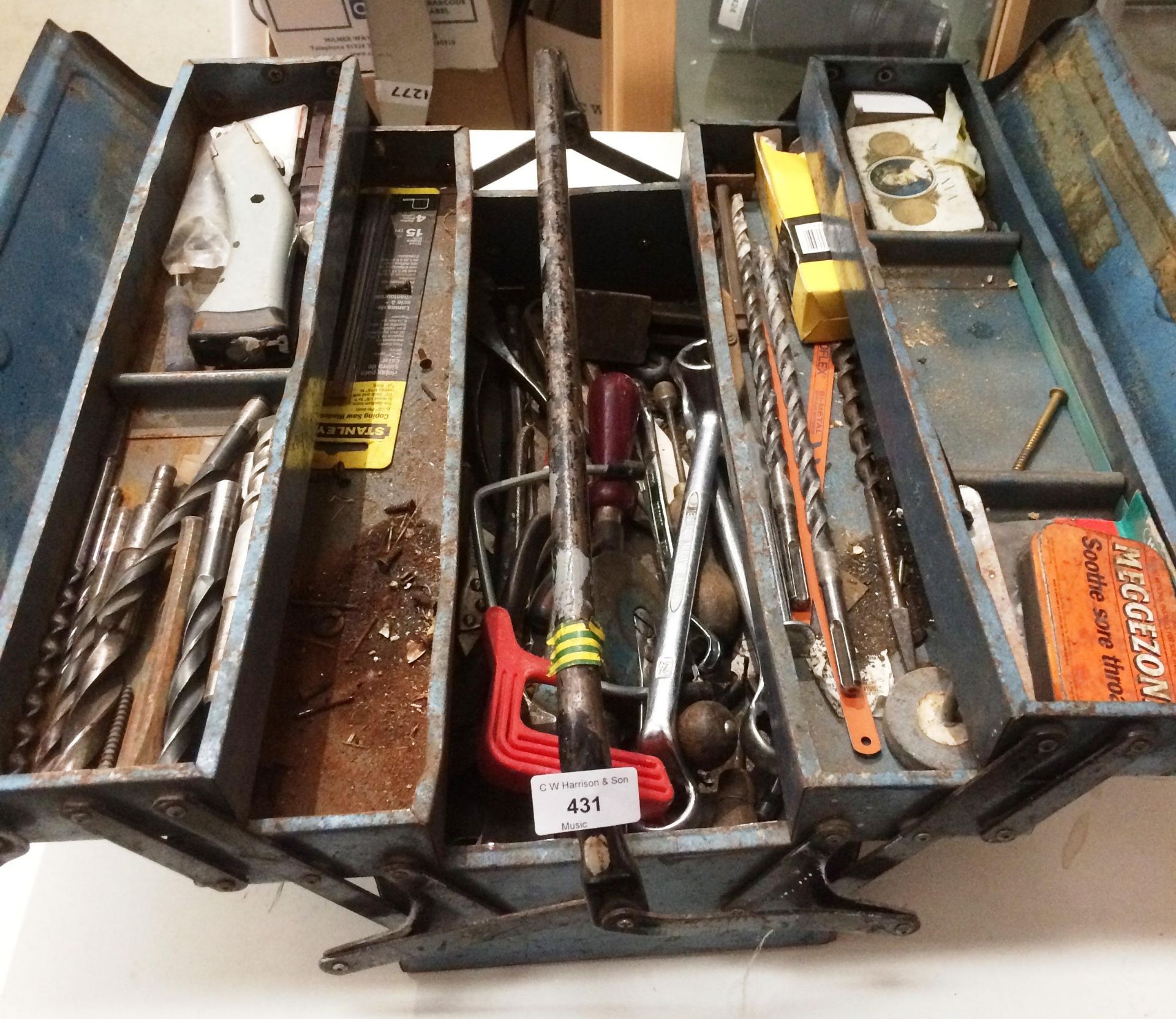 A blue metal toolbox and contents - assorted drill bits, spanners,