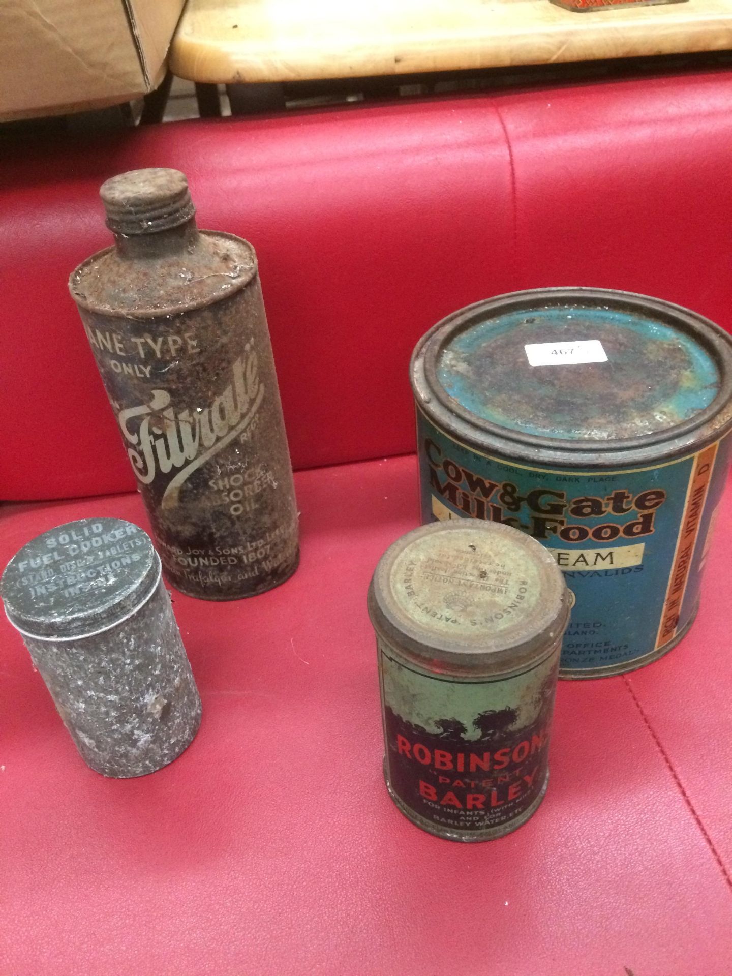 A vintage tin advertising Filtrate Shock Absorber Oil , a Cow & Gate Milk Food tin and two others,