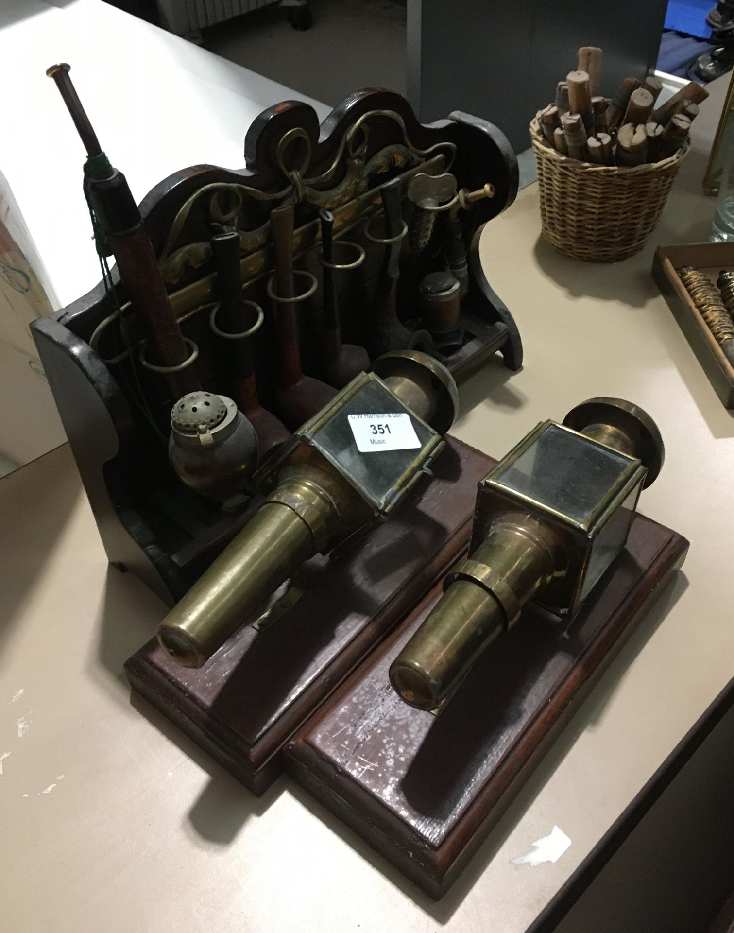 Pipe rack and pipes and 2 small brass lamps on plinths Further Information One