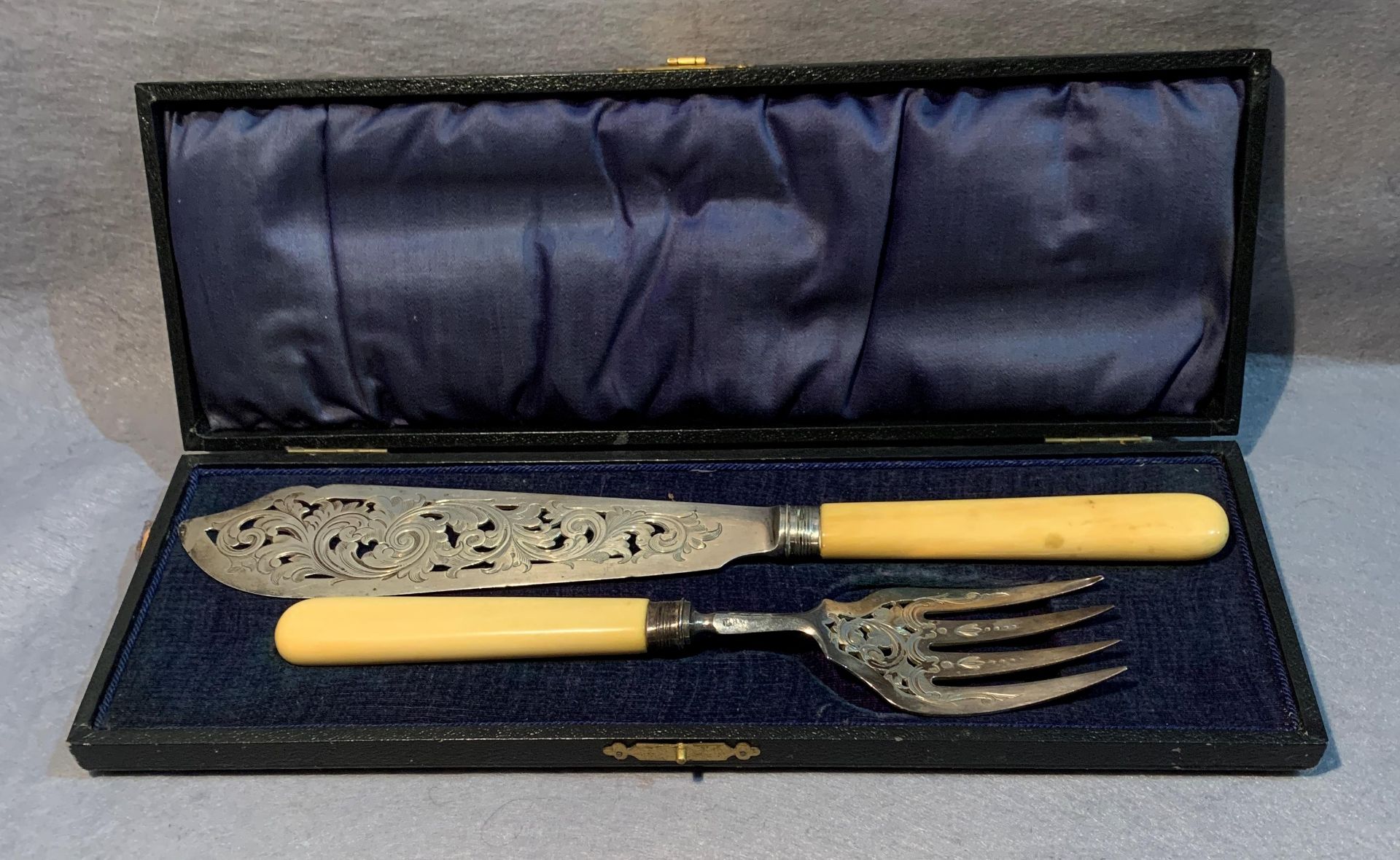 A silver fish knife and fork with bone handles in presentation case