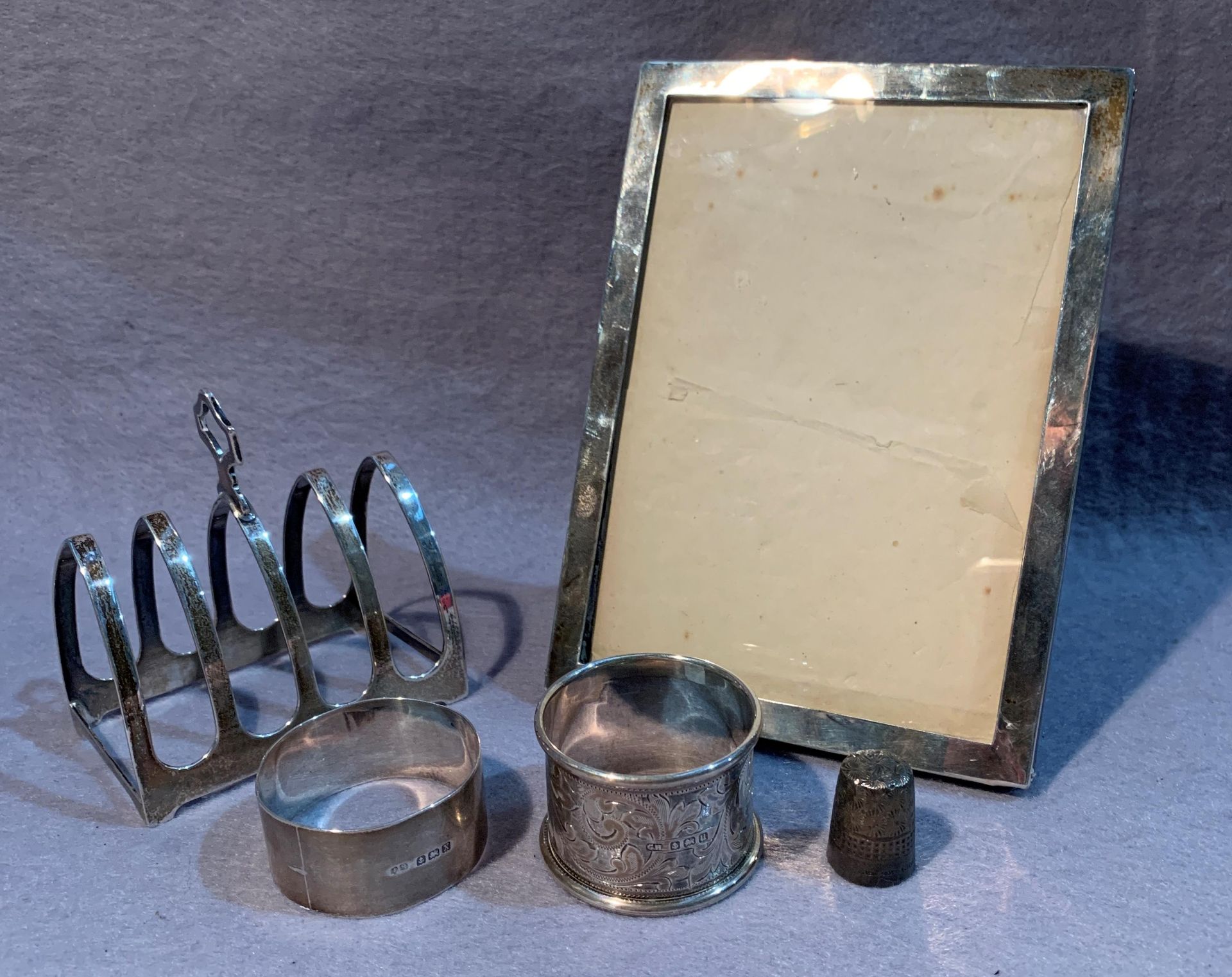 A silver photograph frame, a silver four division toast rack,