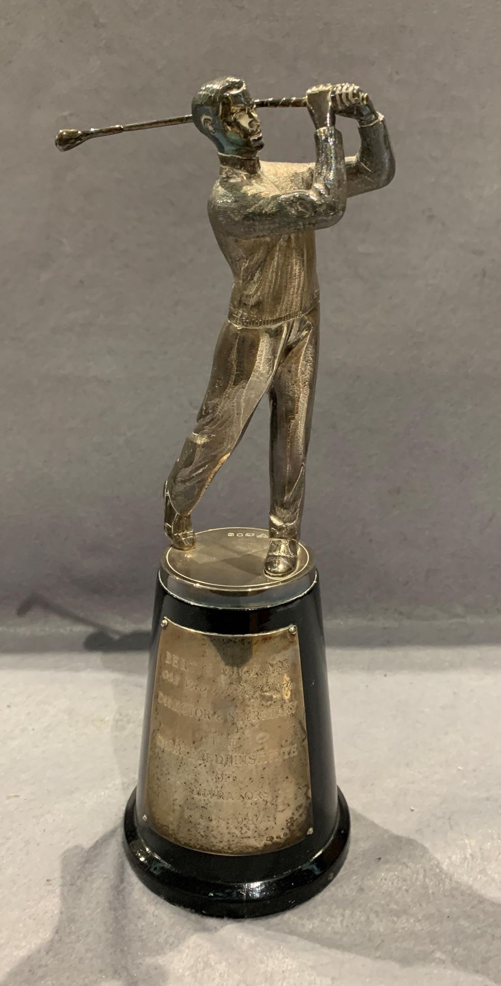 A silver golf trophy modelled as a golfer, on a plinth, with silver presentation plaque,