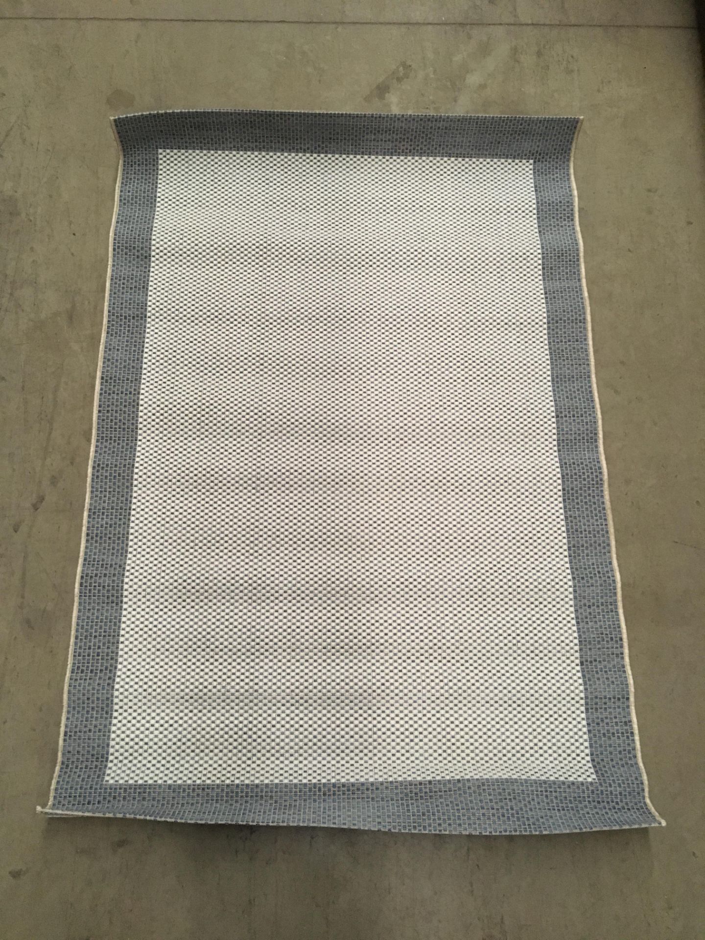 A blue and white patterned rug - 115cm x 170cm