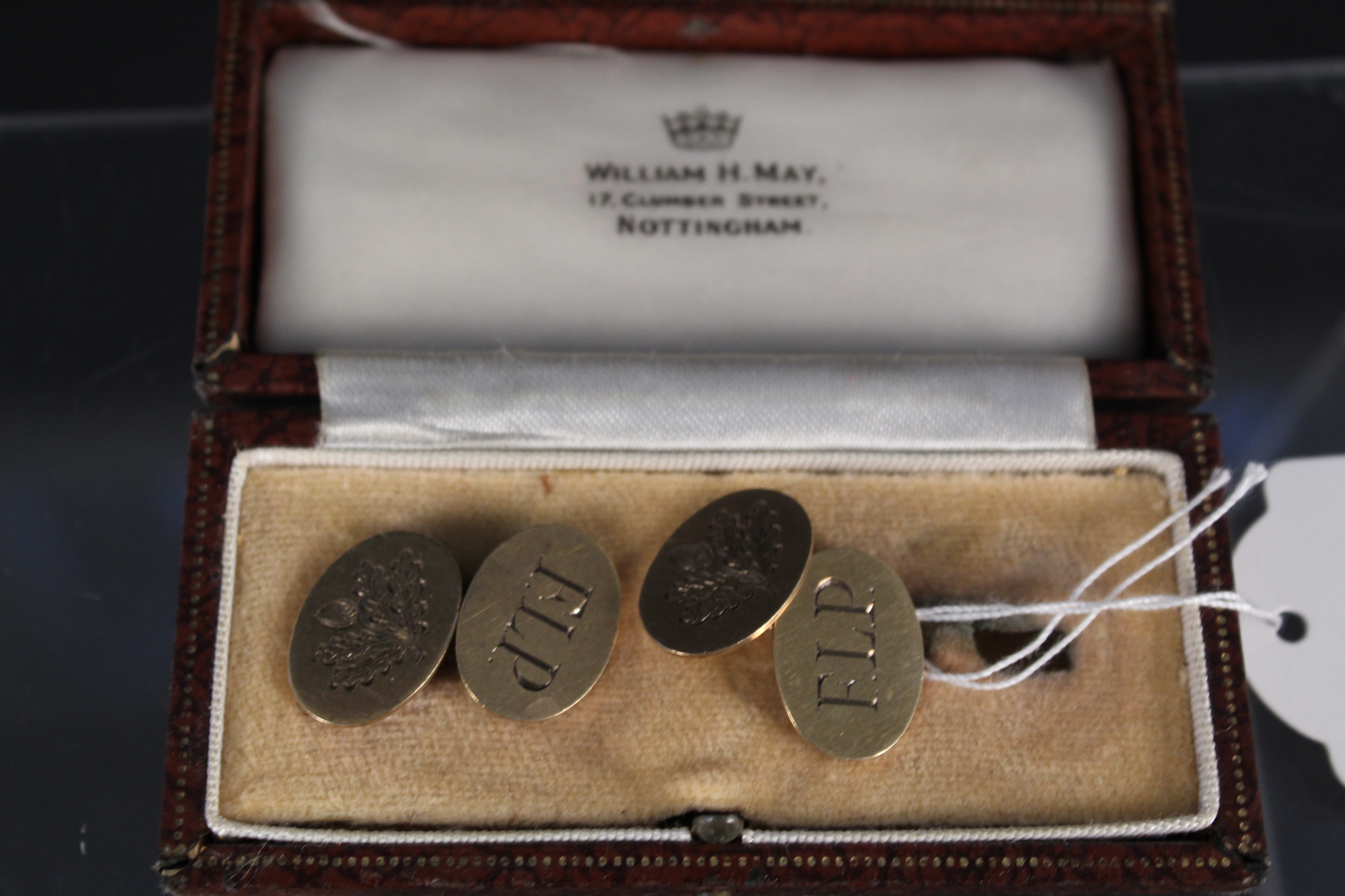 A pair of 9ct gold oval cufflinks with engraved initials to one side and engraved acorn to the