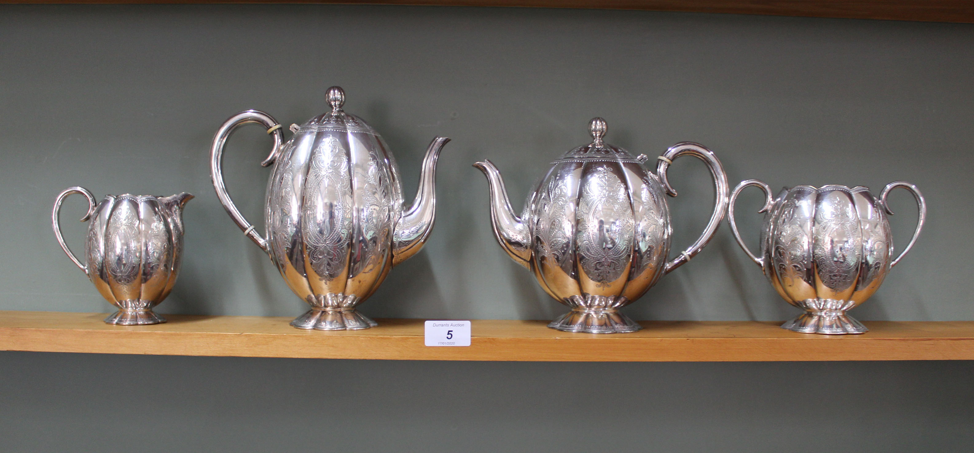 A silver plated melon fluted four piece tea set with engraved decoration