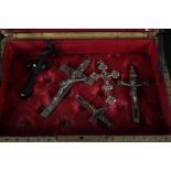 A leather jewellery box and contents, mostly white metal crucifixes,
