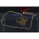 A 9ct gold cigar cutter on thin 9ct gold chain with three various coins in 9ct gold mounts