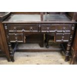 A 1920's leather topped four drawer writing desk with stretcher base