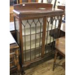 A 1940's carved mahogany two door glazed display cabinet