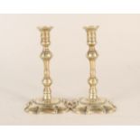 A pair of 18th Century small brass candlesticks or tapersticks with multi knopped stems and petal