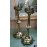 A pair of large early 20th Century Gothic style brass church pricket candlesticks raised on three