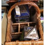 A wicker picnic basket with bottle compartments plus two metal and glass hanging lanterns