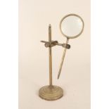 A Stanley of London three point adjustable brass magnifying glass on stand,