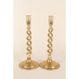 A pair of Edwardian open barley twist brass candlesticks on circular bases,