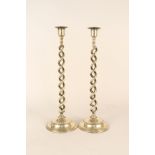 A pair of tall Edwardian open barley twist brass candlesticks with detachable sconces and domed