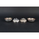 Four Middle Eastern white metal bowls with engraved decoration on bun feet