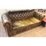 A three seater Chesterfield sofa in aged dark green leather with button back