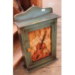 A green painted wall key cabinet with violin painting to door