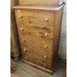 A tall pine chest of five drawers