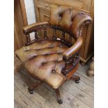 A modern Victorian style swivel desk chair with leather button back upholstery